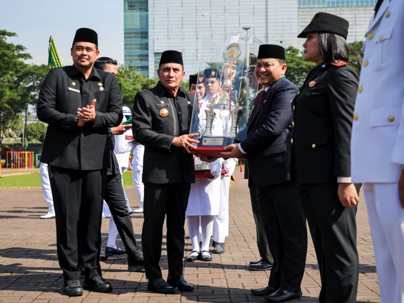 Gubernur Sumut, Edy Rahmayadi Bersama Wali Kota Medan, Bobby Nasution Memberikan Penghargaan Kepada Harry Indrawan Tarigan (Camat Medan Tuntungan) Dalam Upacara Penyerahan Tanggul Kecamatan Terbaik tingkat Provinsi Sumut Kategori Kota Tahun 2022 di Lapangan Benteng, Senin (30/1)