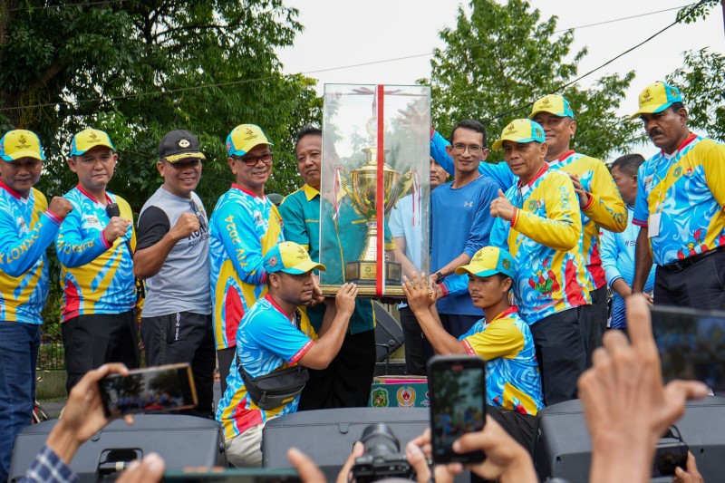 Kadis Pemuda dan Olahraga, Dammikrot Harahap Menyerahkan Piala Bergilir Kepada Kecamatan Medan Deli Yang Keluar Sebagai Juara Umum Pada Porkot XIV di Lapangan Balai Desa Jalan Beringin 2, Sabtu (22/6/2024)