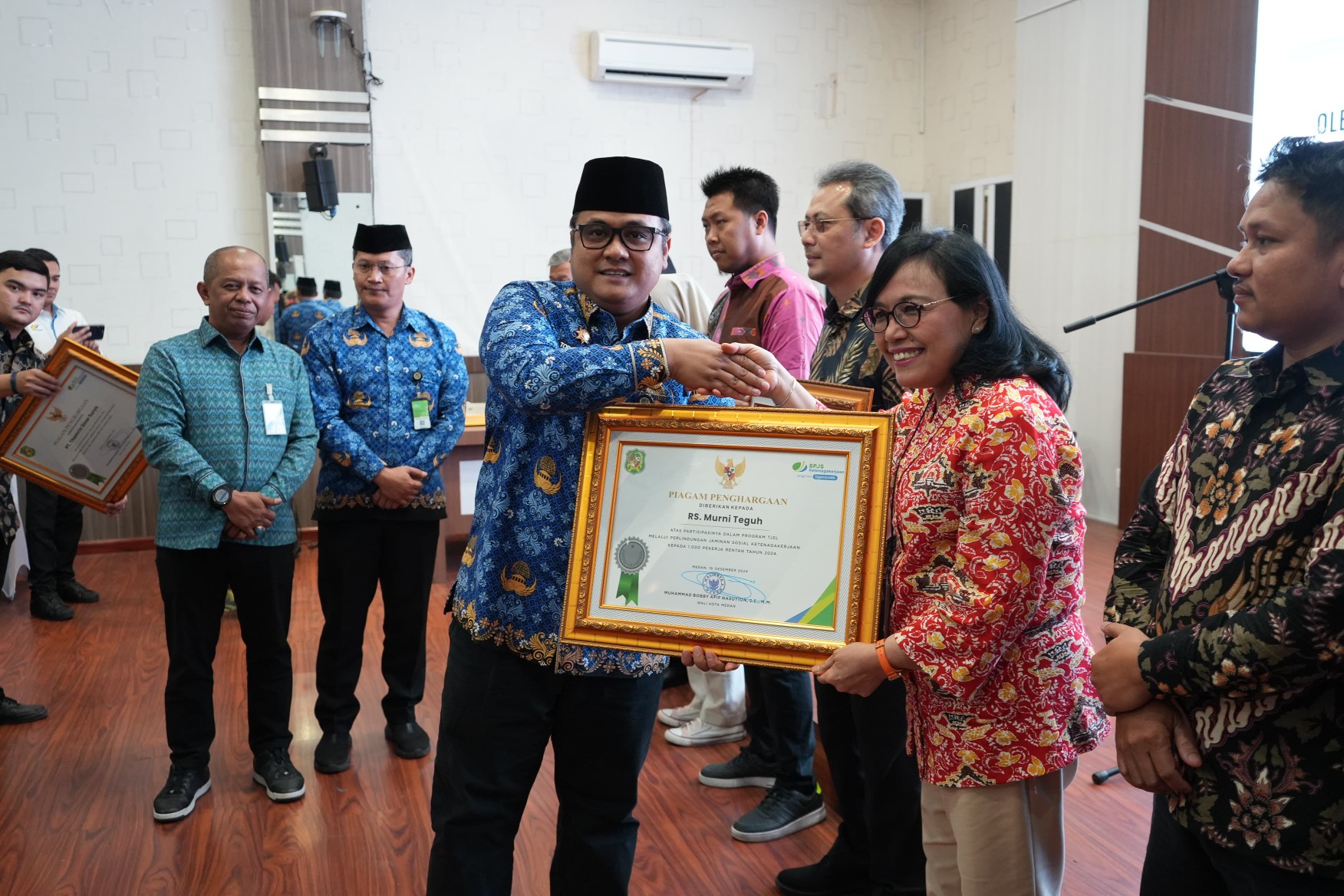 Pj Sekda Kota Medan, Topan Obaja Putra Ginting Menyerahkan Piagam Penghargaan Kepada Perusahaan Yang Dukung Perluasan Cakupan Kepesertaan Jaminan Sosial Ketenagakerjaan  di Kantor Wali Kota Medan, Kamis (19/12/2024)